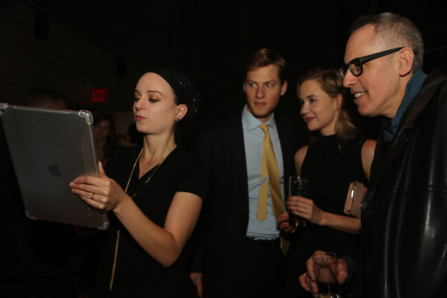 Live sketch artist drawing portraits on an iPad while guests watch at an event