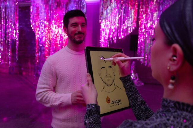 Human sketch artist drawing a guest at a branded event instead of a sketchbot
