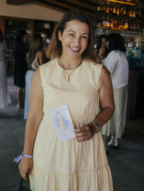 Guest smiling with her finished fashion portrait at the Savage X Fenty summer party