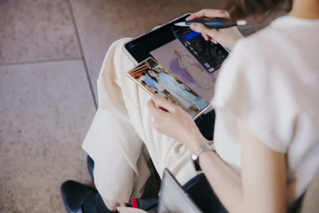 Drawing Booth artist using a guest photo reference to create a live digital fashion illustration
